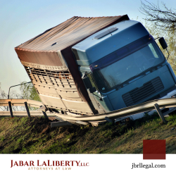 Cargo truck leaning into damaged guard rail after truck accident