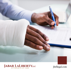 Person with broken arm signing personal injury lawsuit paperwork