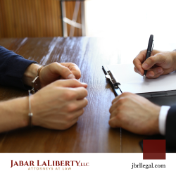 Person in handcuffs talking to a criminal defense lawyer